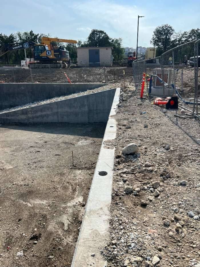 Reinforced concrete detention pond wall with a drilled core hole
