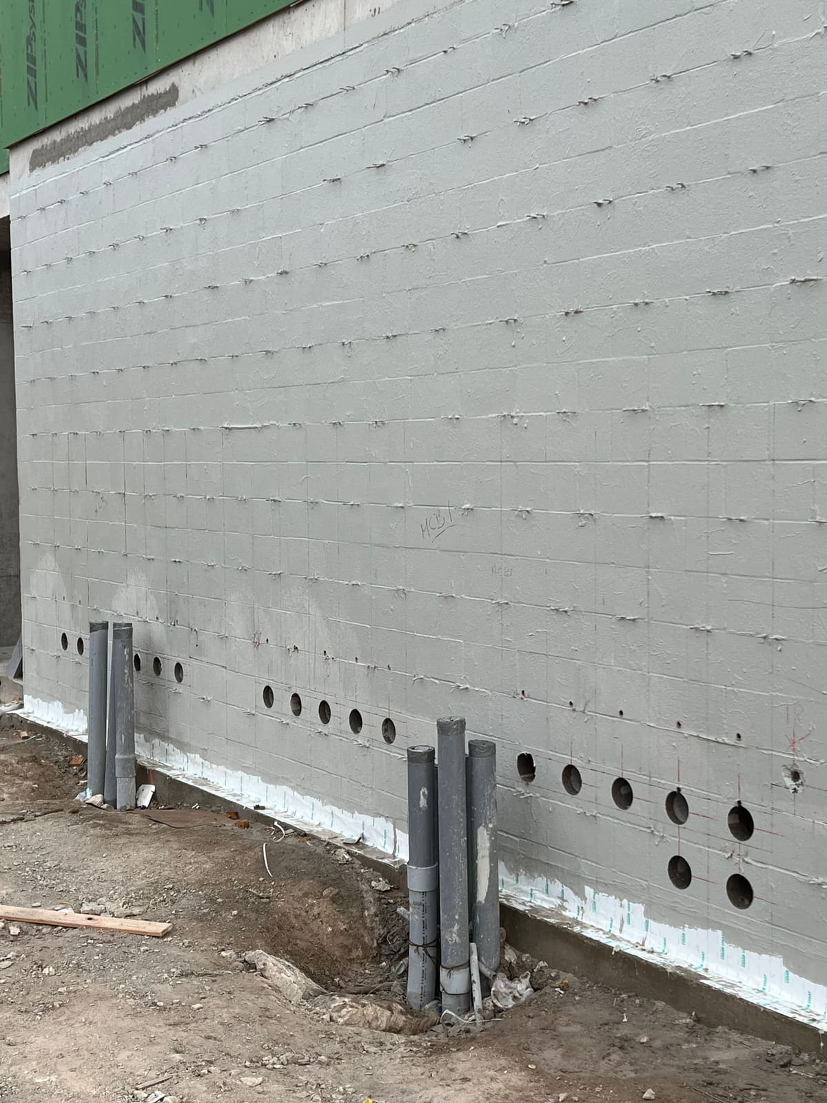 Capped core penetrations beside a concrete column inside a CMU building
