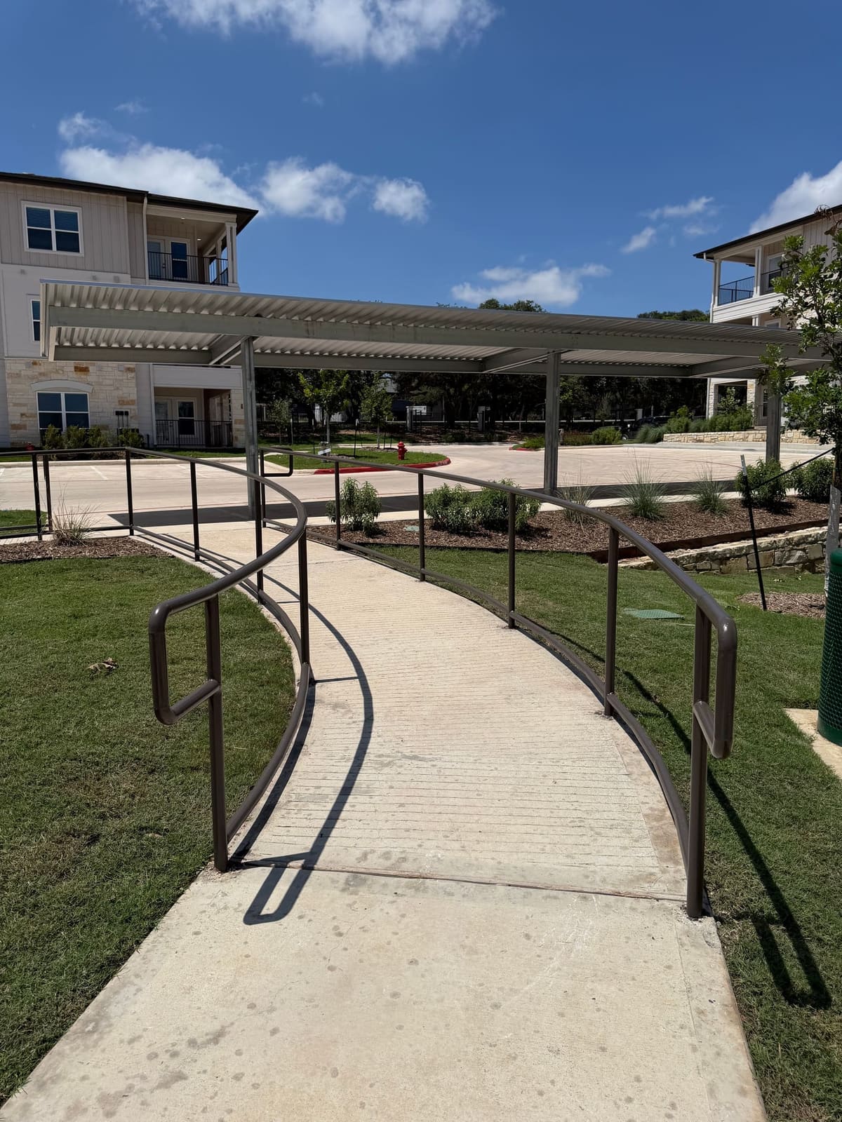 Curved accessible ramp with handrails anchored into concrete