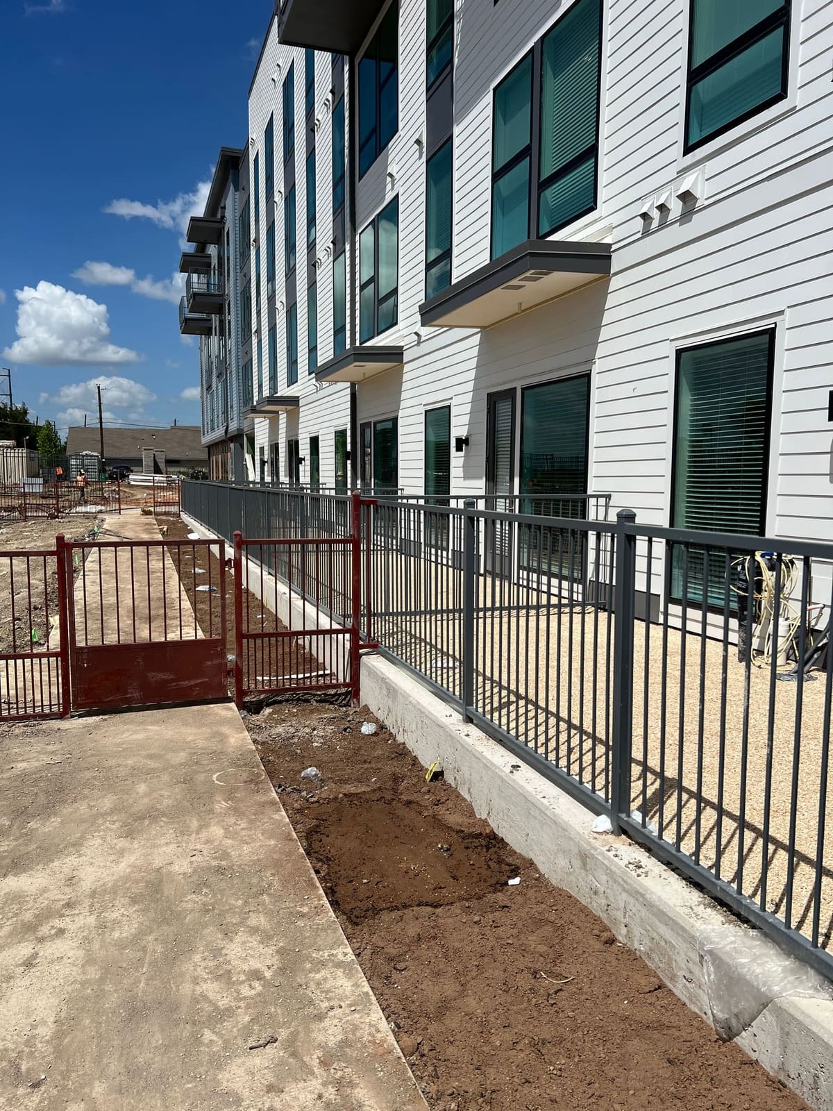 A retaining wall base drilled along a resident walkway ahead of fence installation