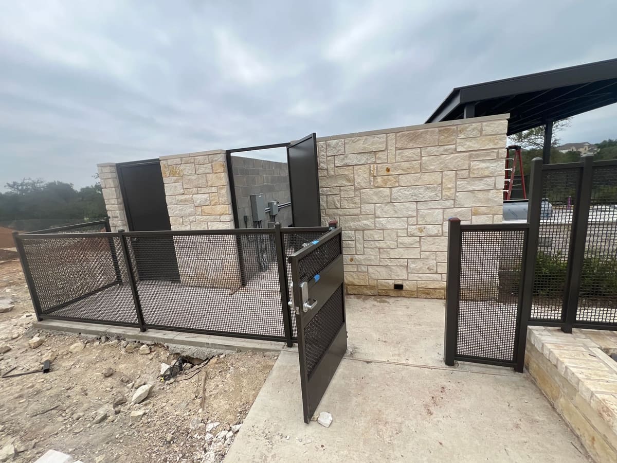 Steel mesh gate mounted into a stone block enclosure wall