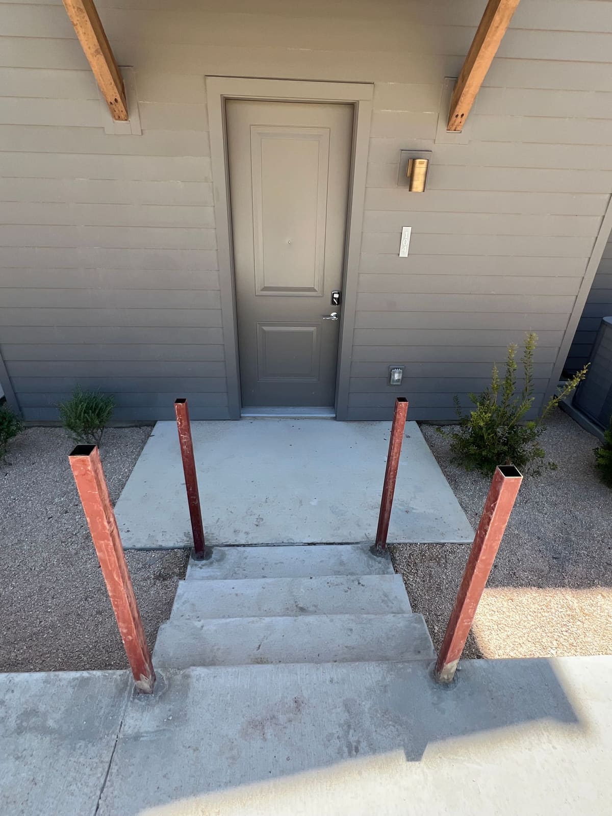 Steel posts set at a building entry, ready for handrail installation